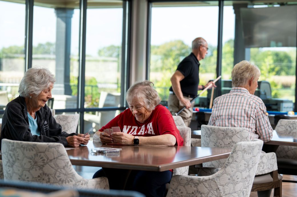 seniors playing cards and smling