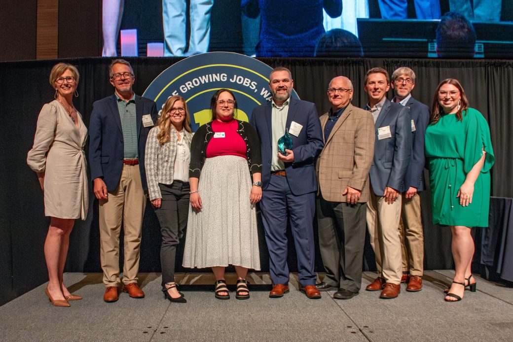 group of people on stage with award