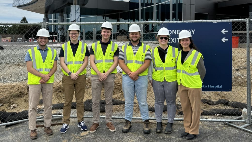 group of people in hard hats in front of building