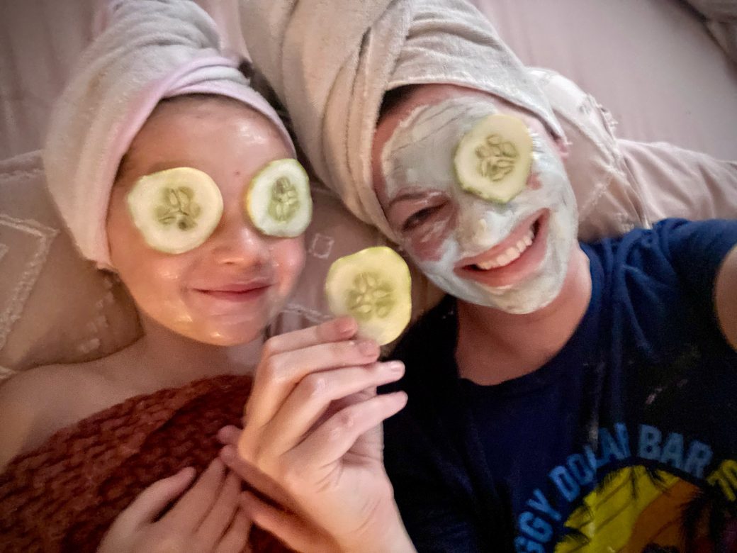 two people with cucumbers and face masks